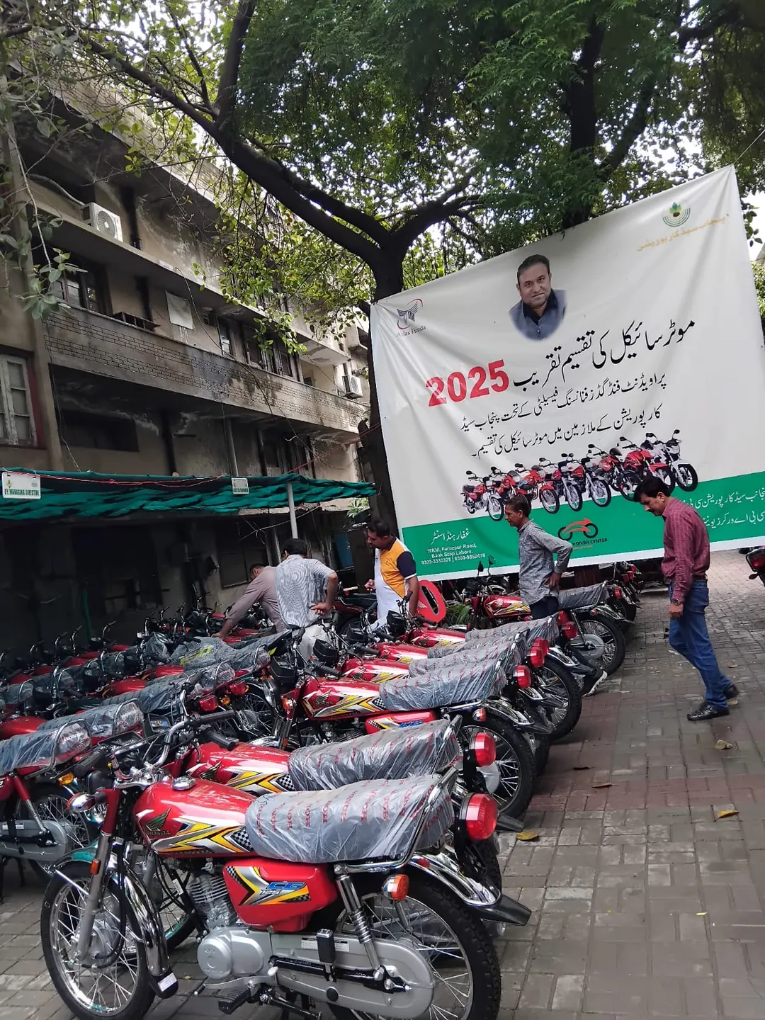 Punjab Seeds Corporation delivery staging with banner and motorcycles